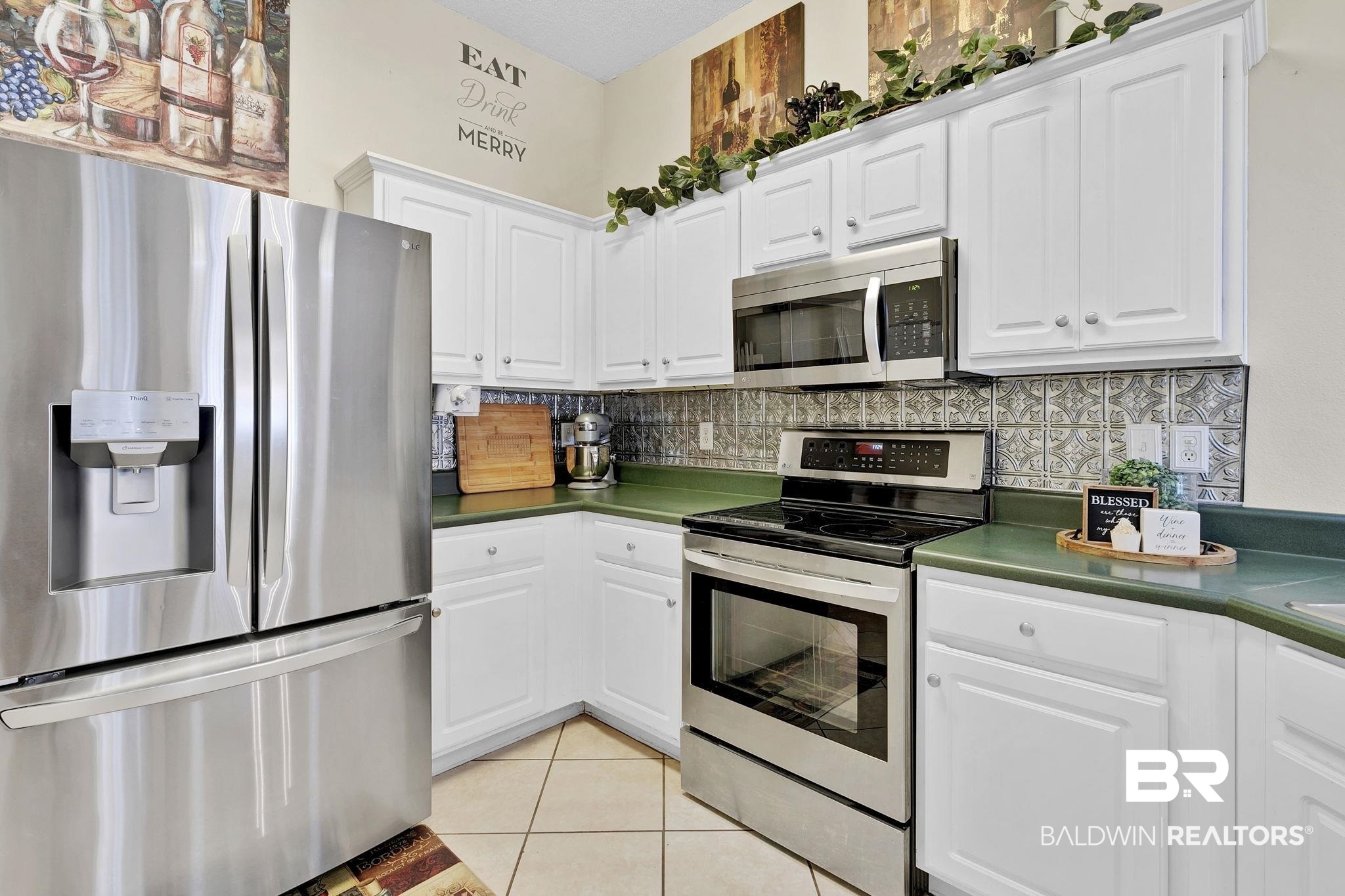11103 Pontchartrain Loop Daphne, AL 36526 - Photo 18 of 29 Kitchen with light tile patterned floors, backsplash, stainless steel appliances, and dark countertops