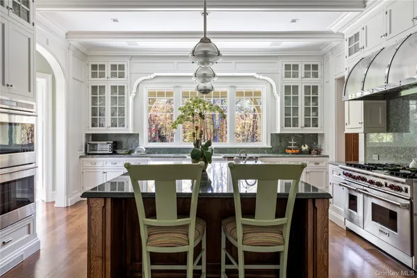 a kitchen with stainless steel appliances granite countertop a sink a stove and cabinets