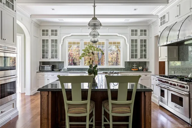 a kitchen with stainless steel appliances granite countertop a sink a stove and cabinets