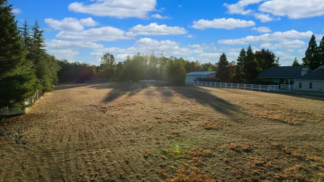 a view of a yard with wooden fence