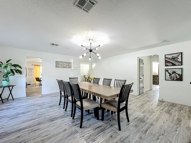 a kitchen with stainless steel appliances granite countertop a stove top oven a sink dishwasher and a microwave oven on the wooden floor