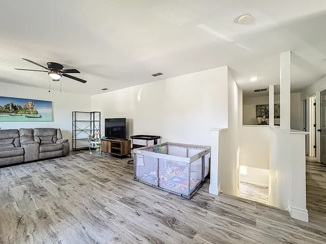 a living room with furniture and a ceiling fan