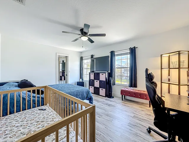 a bedroom with a bed wooden floor and a desk