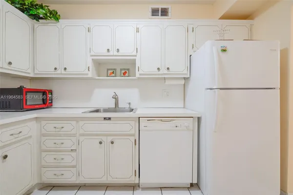 a kitchen with white cabinets and white appliances