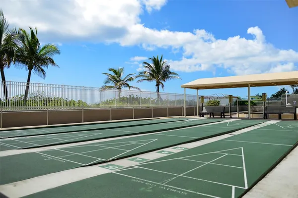 a view of a tennis ground with palm trees
