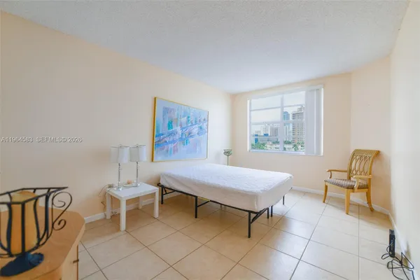 a bedroom with a chair and a window