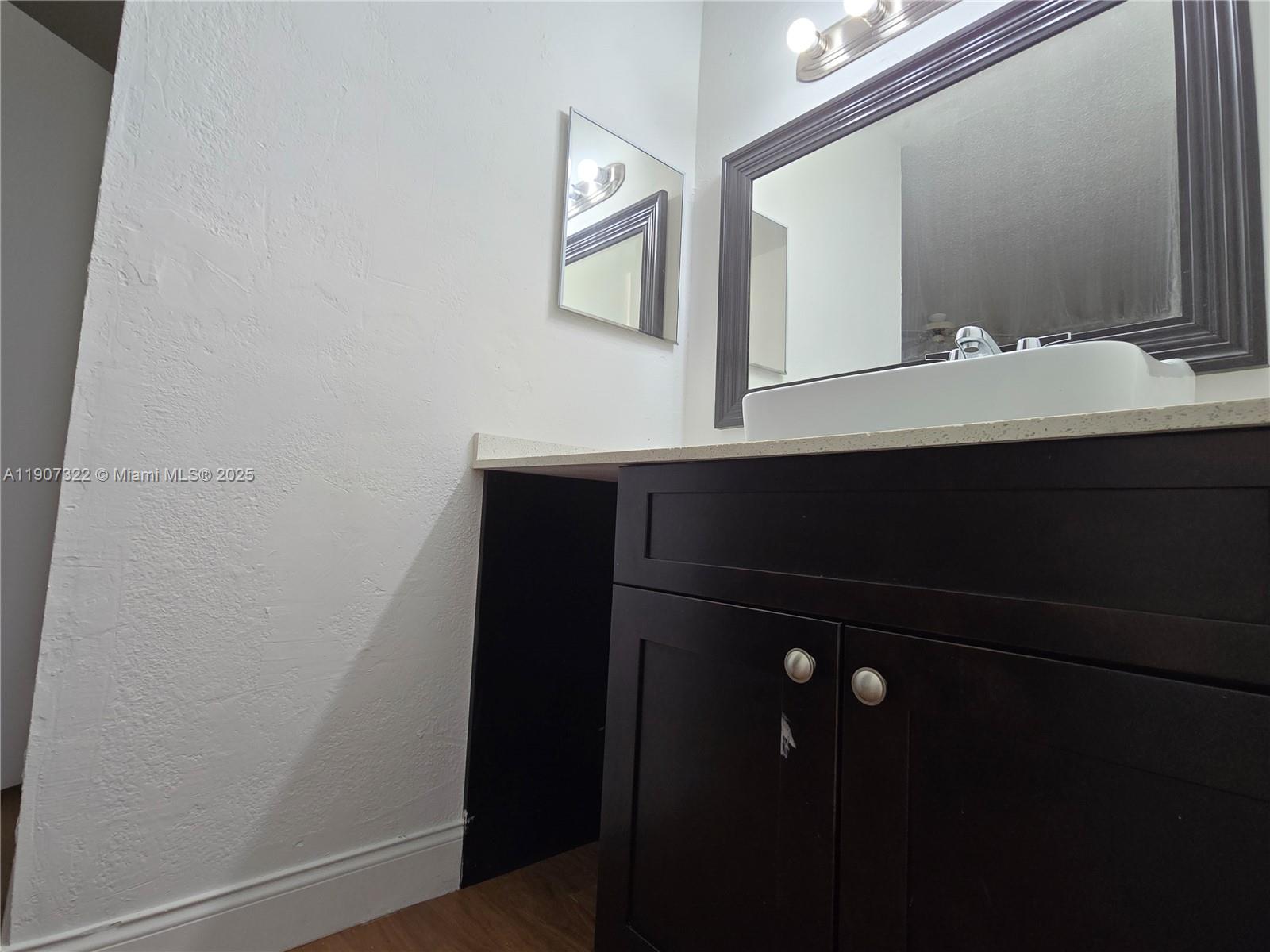 2650 Northwest 60th Way, Unit 176 Sunrise, FL 33313 - Photo 13 of 20 a bathroom with a sink and a mirror