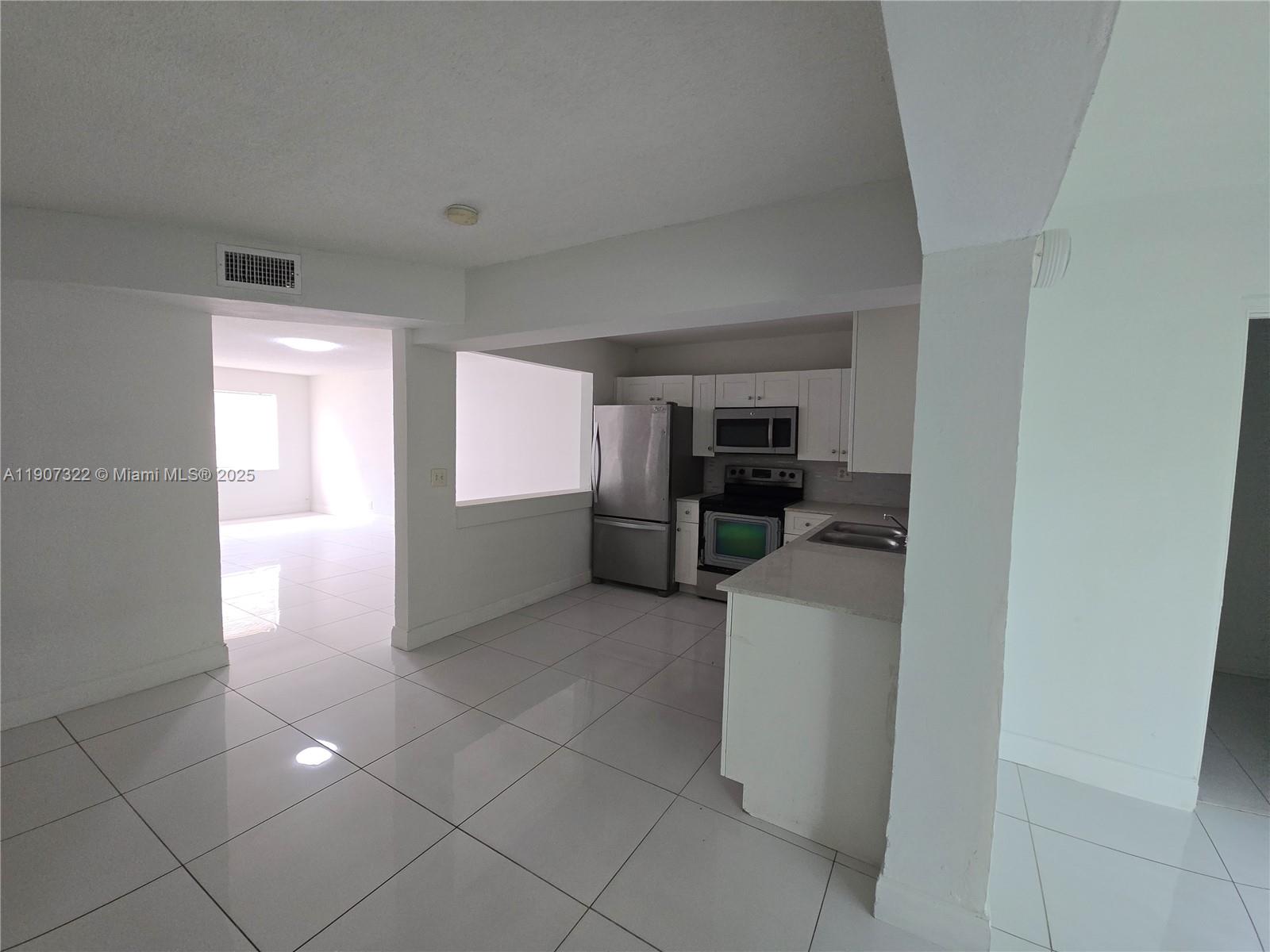 2650 Northwest 60th Way, Unit 176 Sunrise, FL 33313 - Photo 2 of 20 a kitchen with stainless steel appliances a refrigerator and cabinets