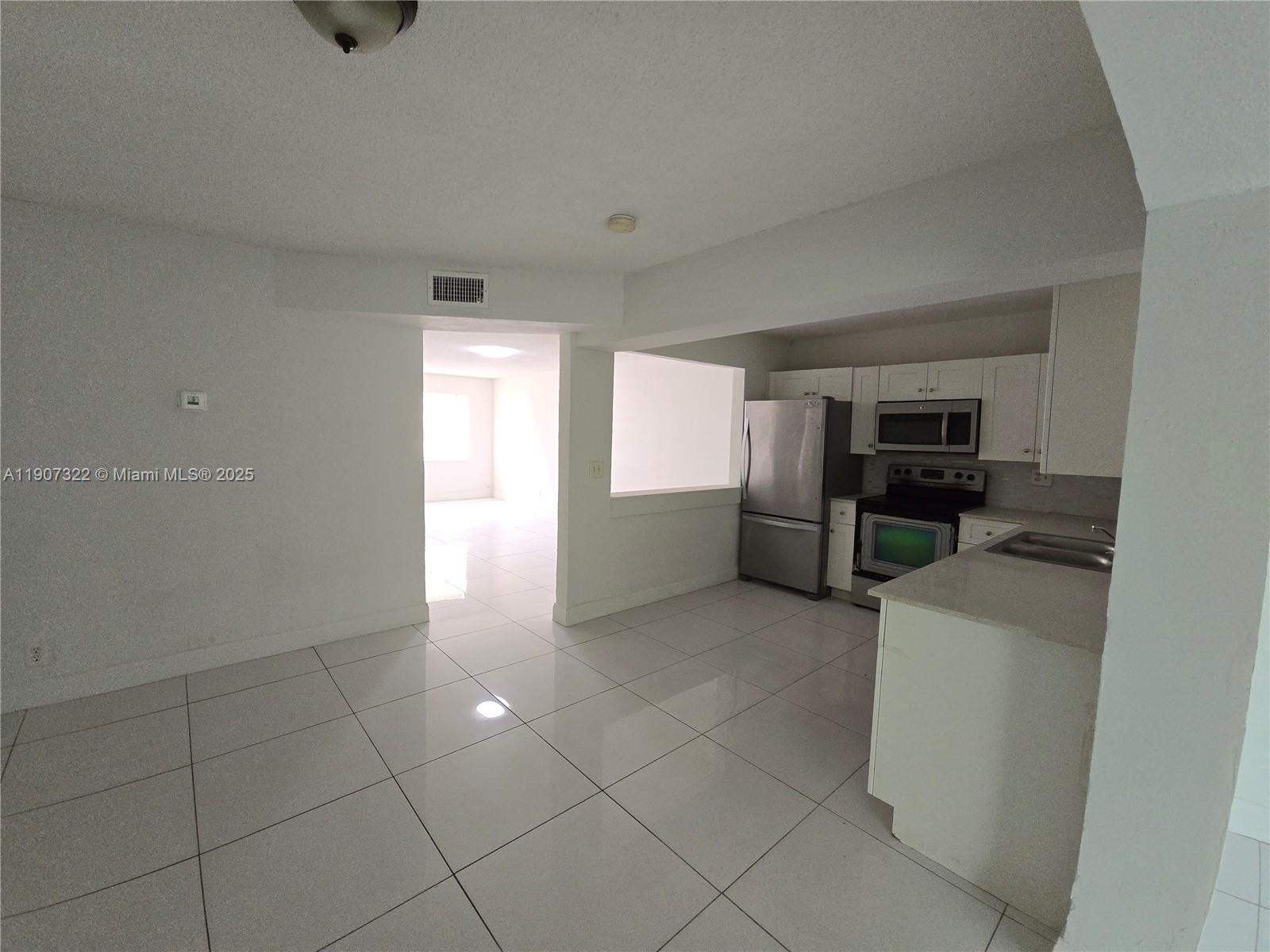 2650 Northwest 60th Way, Unit 176 Sunrise, FL 33313 - Photo 3 of 20 a view of a kitchen with furniture and an empty room