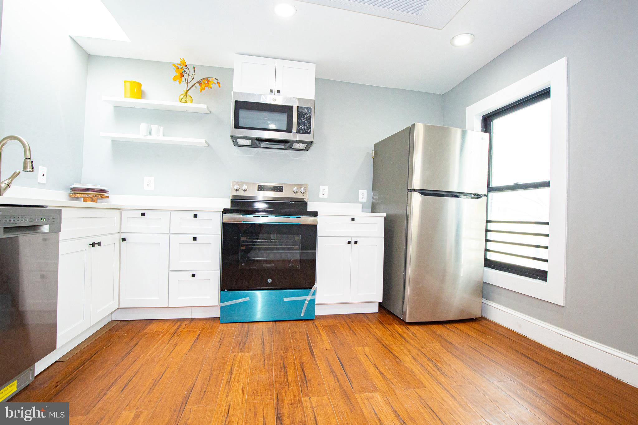 2617 13th Street Northwest Washington, DC 20009 - Photo 4 of 13 a kitchen with stainless steel appliances a refrigerator sink and cabinets