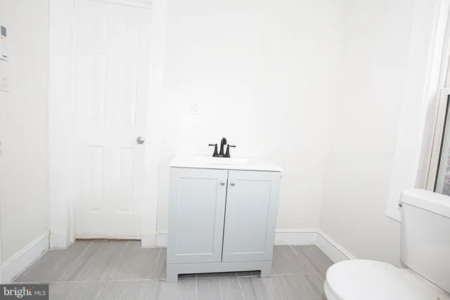 a bathroom with a sink a toilet and mirror