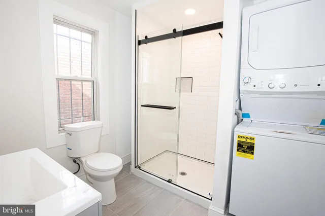 a bathroom with a shower a toilet and a window