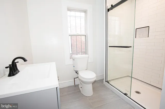 a bathroom with a sink a toilet and a shower