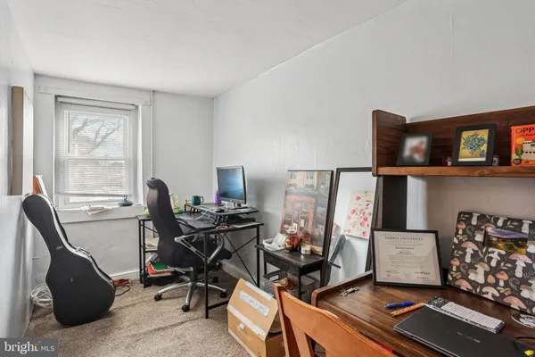 a view of a workspace with furniture and a window