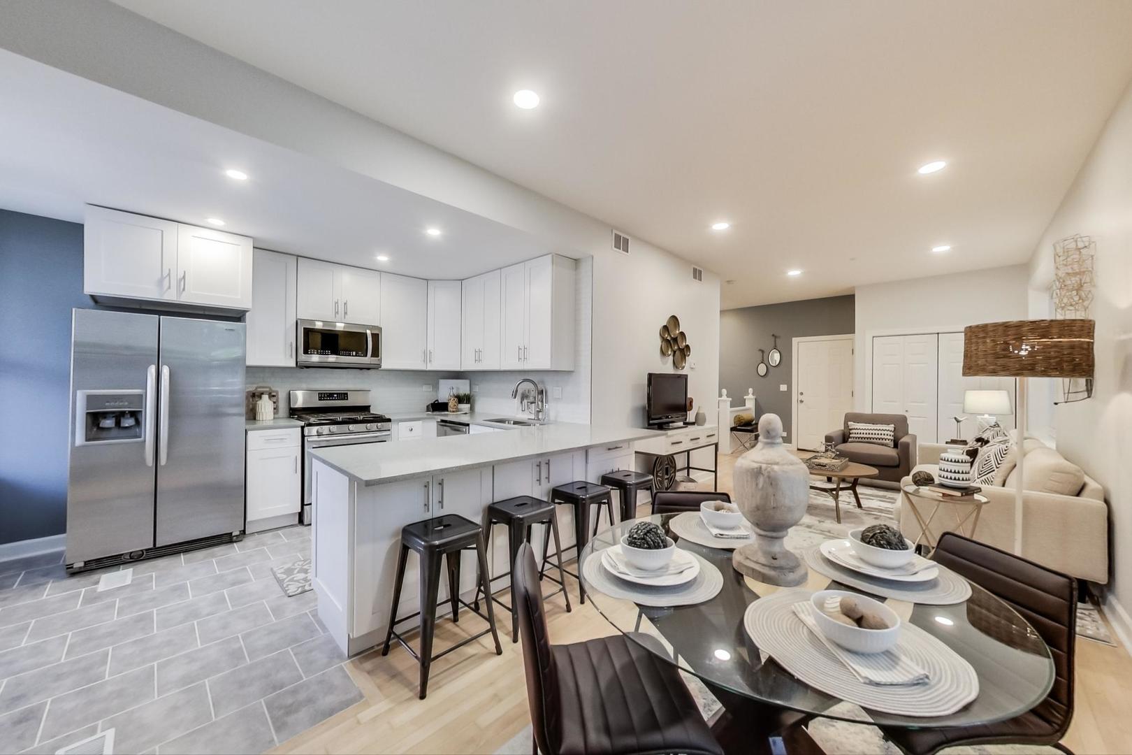 1422 West Lexington Street, Unit 2F Chicago, IL 60607 - Photo 7 of 19 a large kitchen with kitchen island a dining table and chairs