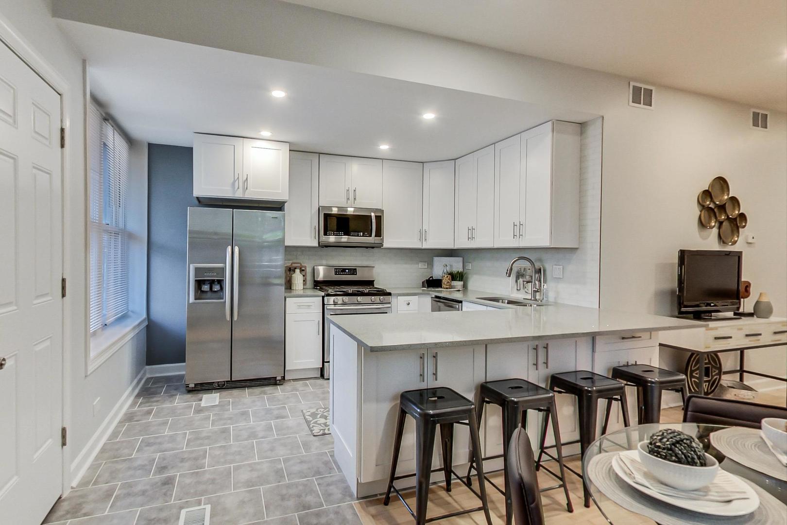 1422 West Lexington Street, Unit 2F Chicago, IL 60607 - Photo 9 of 19 a kitchen with stainless steel appliances granite countertop a refrigerator and a stove top oven