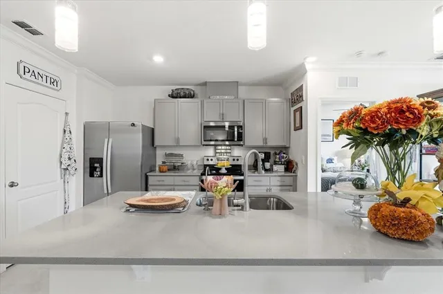 a kitchen with stainless steel appliances granite countertop a refrigerator a stove and a sink