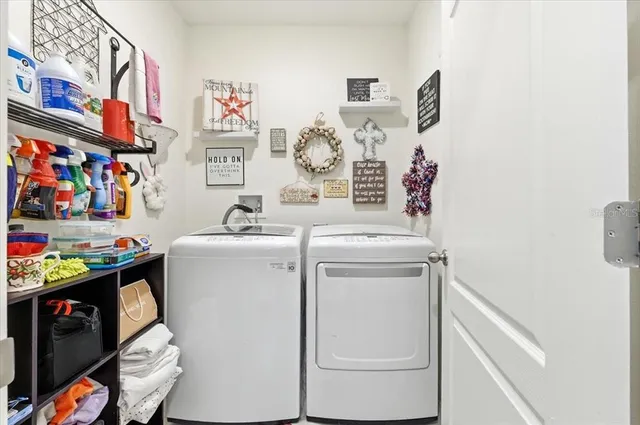 a utility room with cabinets washer and dryer