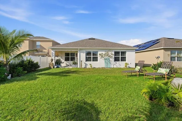 a view of a house with a big yard and potted plants