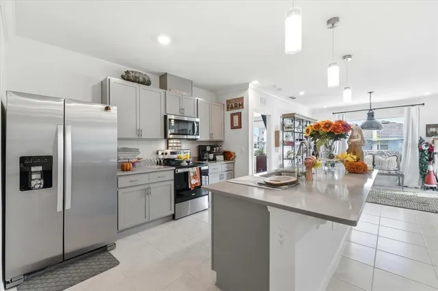 a kitchen with stainless steel appliances granite countertop a sink dishwasher and a refrigerator with white cabinets