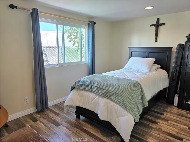 a bedroom with a bed and wooden floor