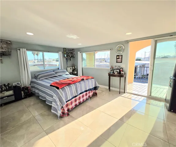 a bedroom with a bed and large window