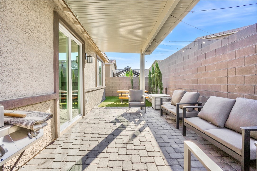 9398 Noble Fir Rdg Court Las Vegas, NV 89143 - Photo 27 of 36 A well-appointed paver patio extends from the home, offering a perfect setting for outdoor relaxation and entertaining.