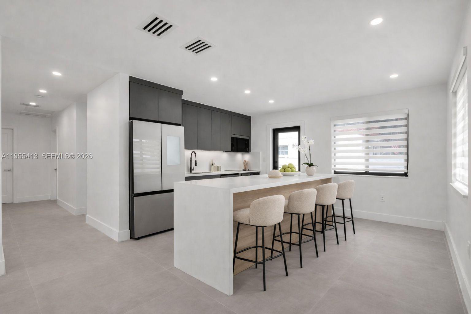 1293 Southwest 22nd Avenue, Unit 1 Miami, FL 33135 - Photo 3 of 28 a kitchen with refrigerator and chairs