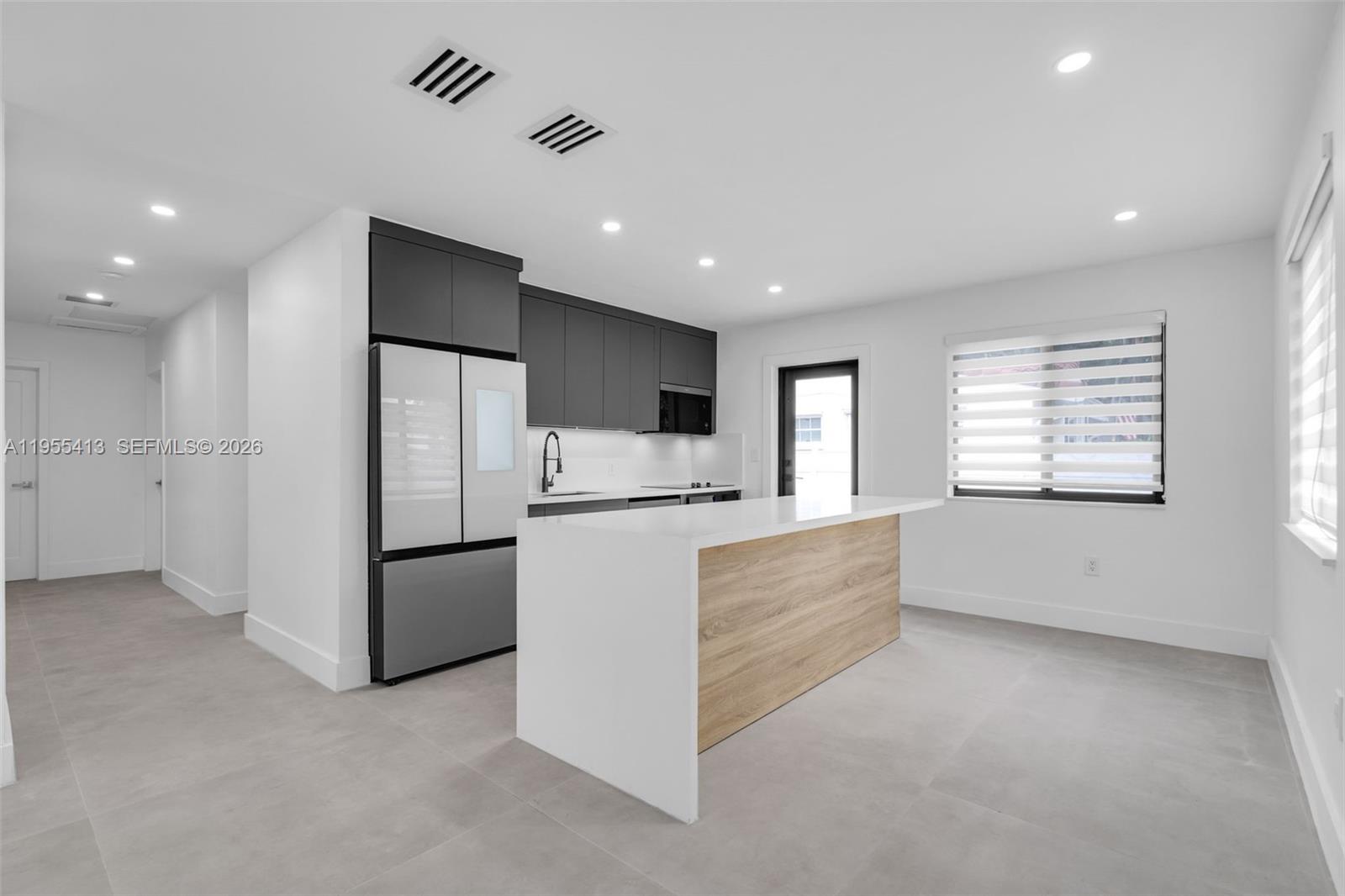 1293 Southwest 22nd Avenue, Unit 1 Miami, FL 33135 - Photo 7 of 28 a large kitchen with stainless steel appliances a refrigerator and a stove top oven