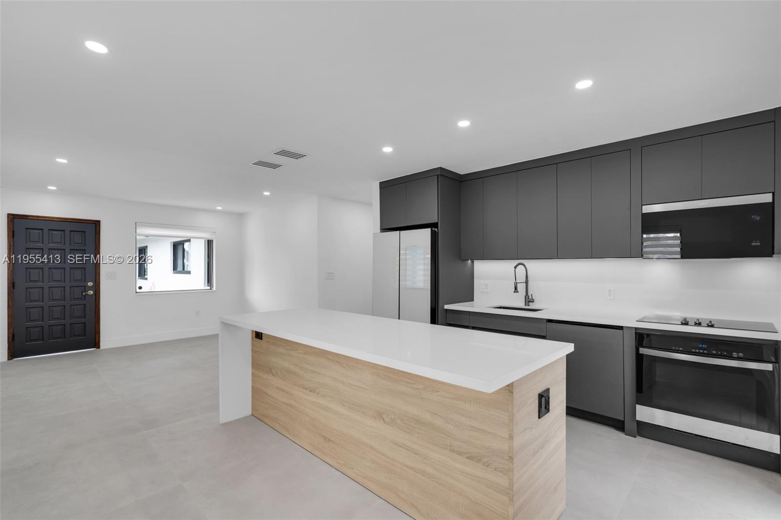 1293 Southwest 22nd Avenue, Unit 1 Miami, FL 33135 - Photo 8 of 28 a kitchen with a sink and a refrigerator
