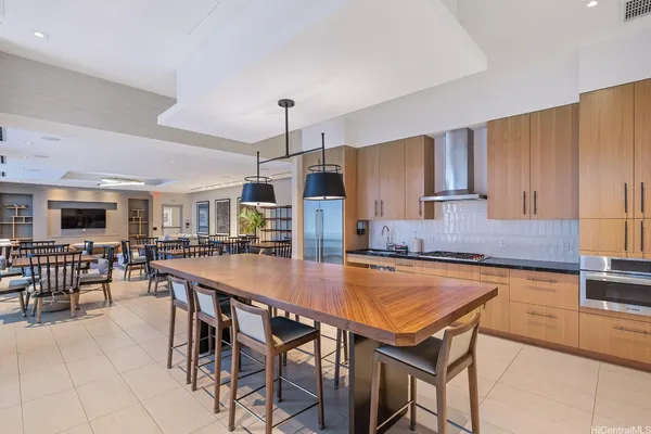 a kitchen with stainless steel appliances granite countertop a table chairs sink and cabinets