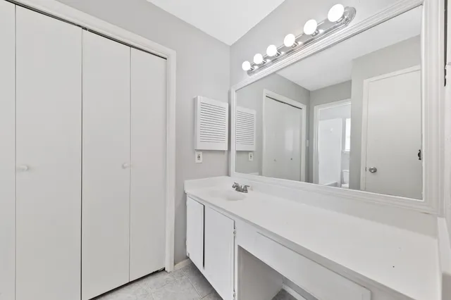 a bathroom with a sink vanity and a mirror