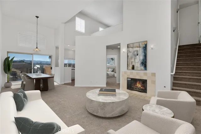 a view of a livingroom with a fireplace a clock and a large window