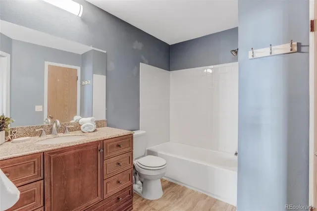 a bathroom with a granite countertop sink toilet a large mirror a bathtub and shower