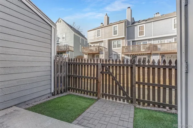 a view of a house with a small yard and wooden fence