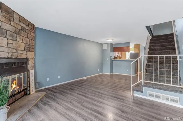 a view of empty room with wooden floor and fireplace