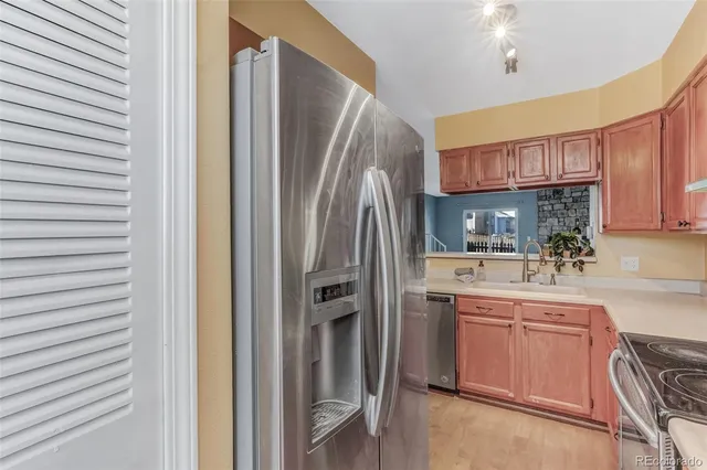 a kitchen with stainless steel appliances granite countertop a refrigerator and a stove