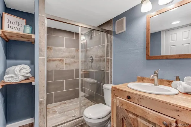 a bathroom with a sink a toilet and shower