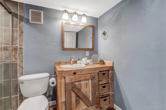 a bathroom with a toilet a sink and mirror