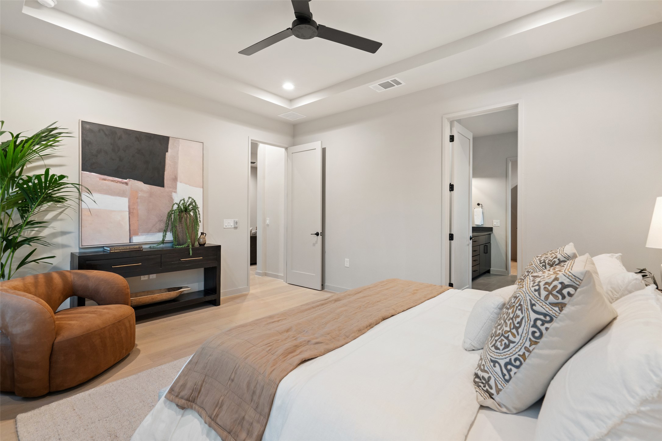 9803 Ribelin Ranch Court, Unit 19 Austin, TX 78750 - Photo 6 of 14 Recessed lighting illuminates this primary bedroom with sleek flooring.