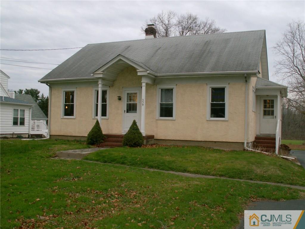 a view of a yard in front of a house with large tree