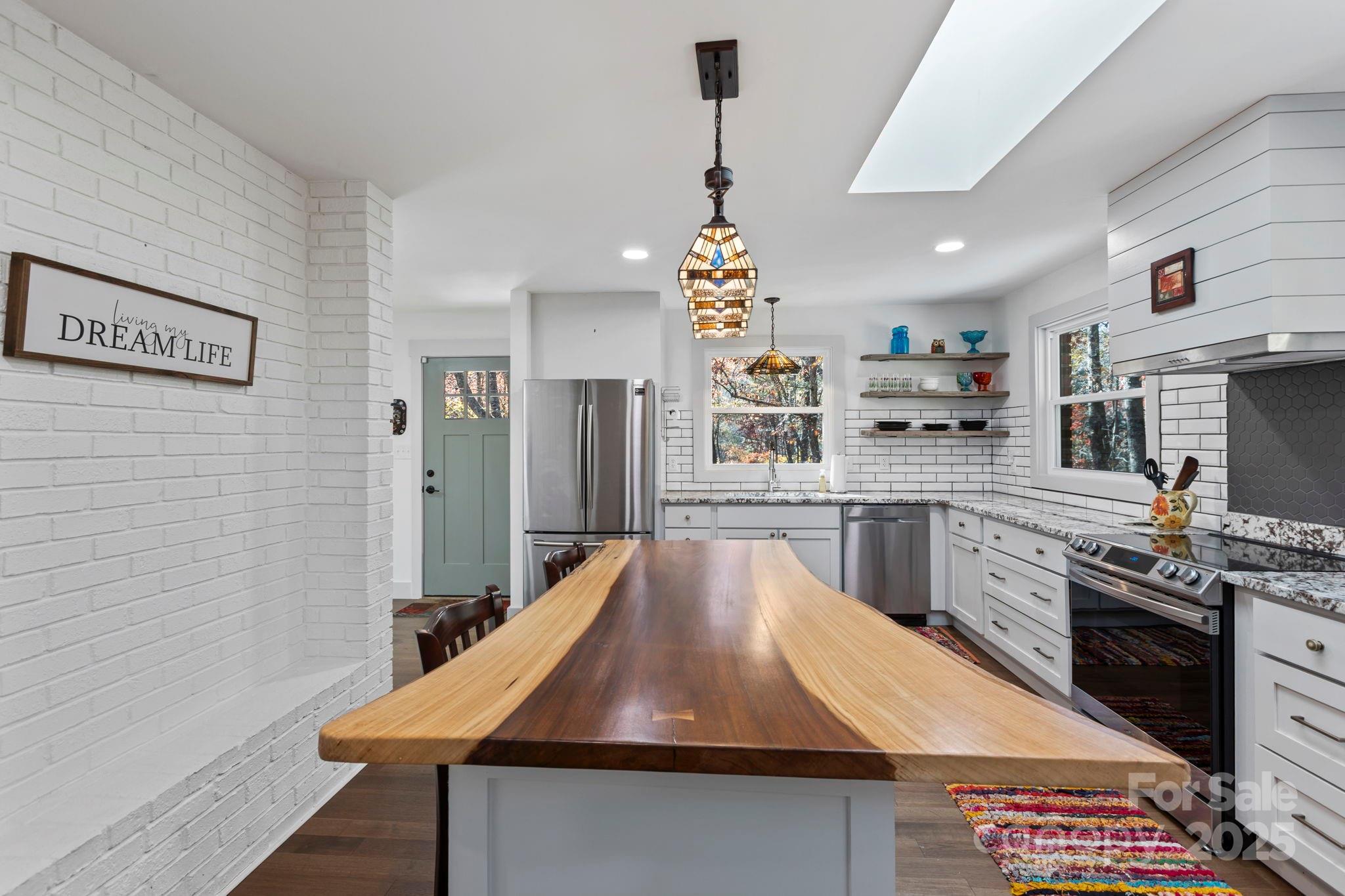 2149 Williamson Creek Road Pisgah Forest, NC 28768 - Photo 13 of 38 a kitchen with stainless steel appliances granite countertop a sink stove and refrigerator