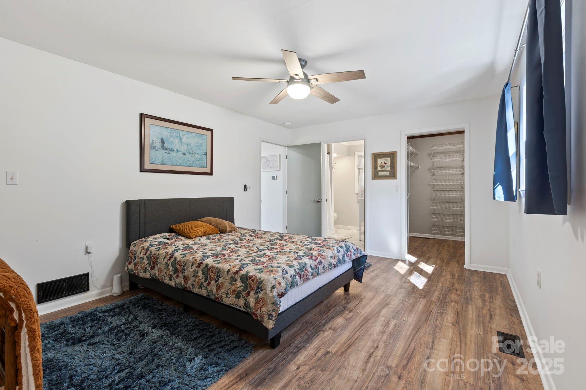 2149 Williamson Creek Road Pisgah Forest, NC 28768 - Photo 17 of 38 a bedroom with a bed and a chandelier