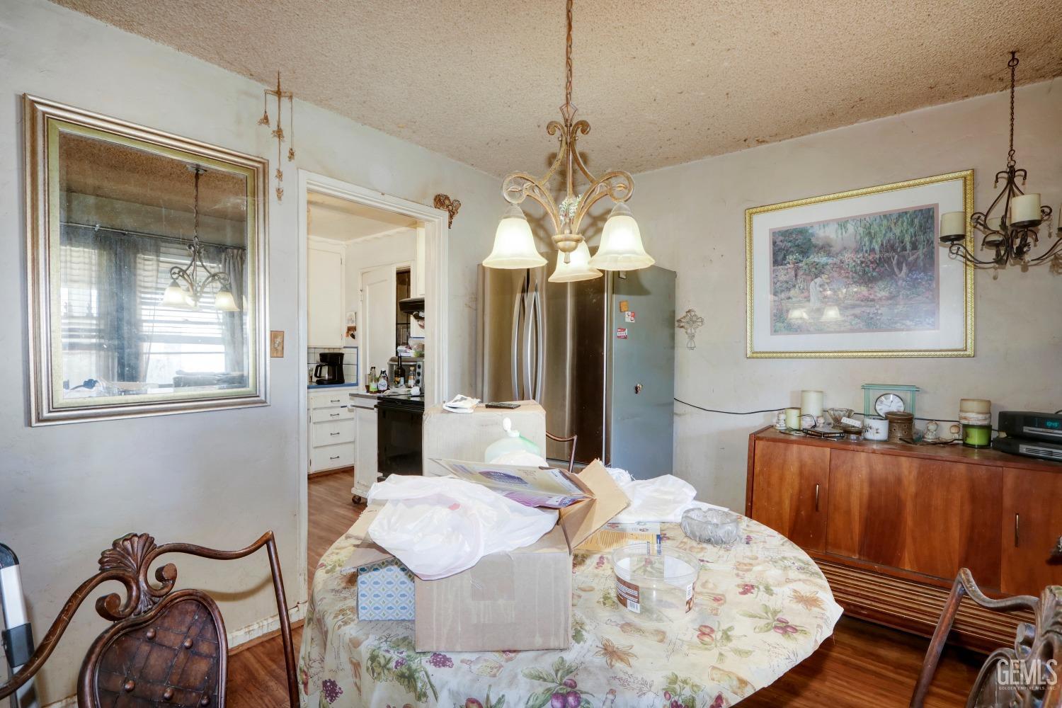 Undisclosed Address Sacramento, CA 95821 - Photo 18 of 33 a dining room with wooden floor a chandelier a wooden table and chairs