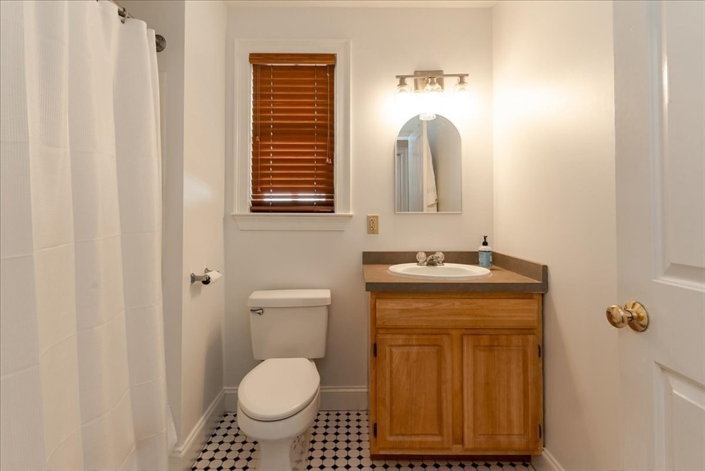 59 Fulda Street, Unit A Boston, MA 02119 - Photo 14 of 18 a bathroom with a granite countertop toilet sink and mirror