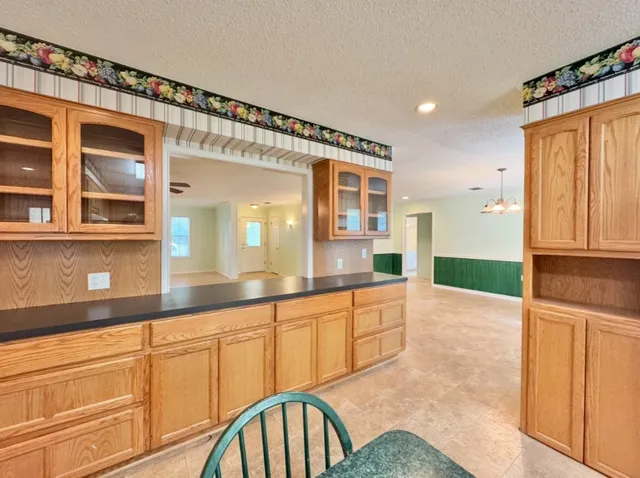 a view of a livingroom with a ceiling fan window and a kitchen view