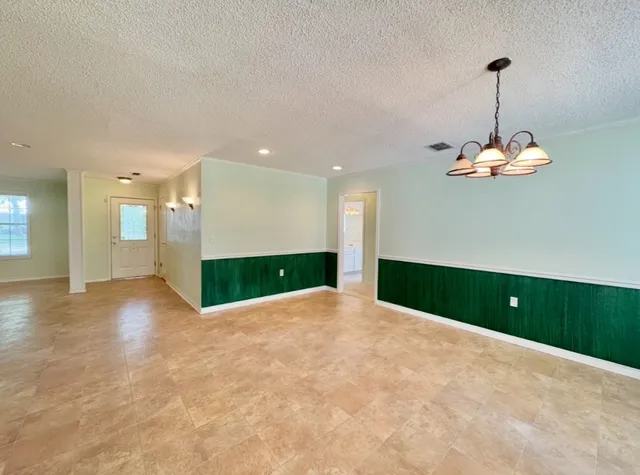 a view of an empty room with a window and a ceiling fan