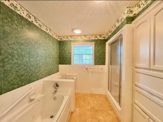 a view of an empty room with window and chandelier fan