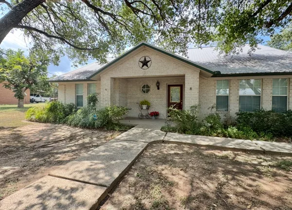 a front view of house with yard and trees around