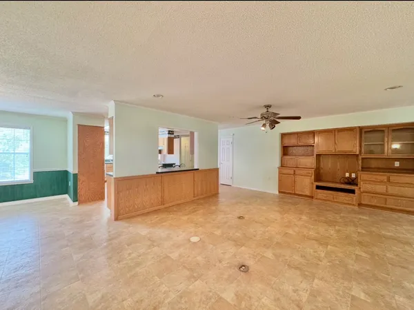 a kitchen with stainless steel appliances granite countertop a refrigerator a sink dishwasher a stove and white countertops with wooden floor